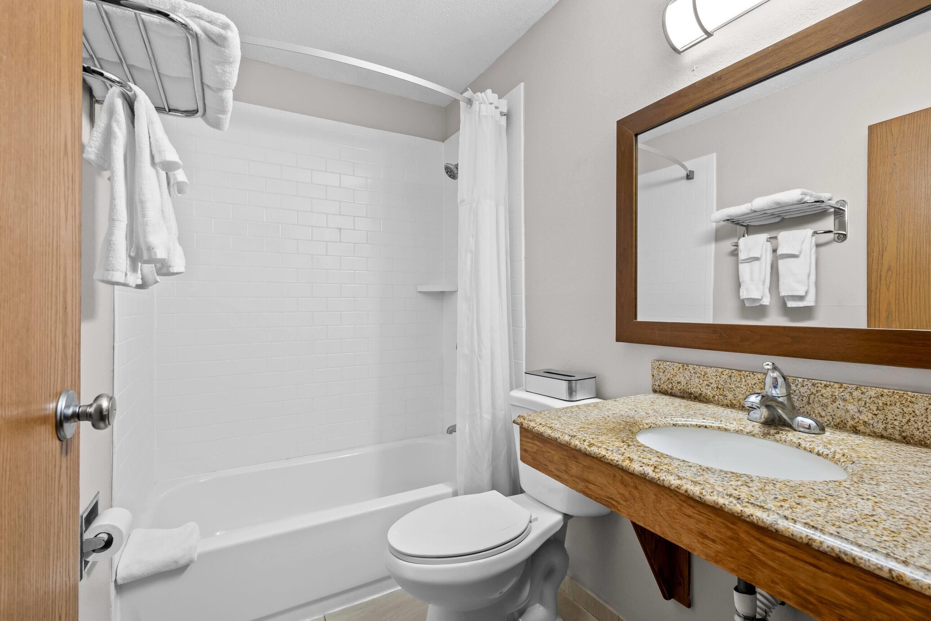 A bathroom with a bathtub, toilet, and sink.