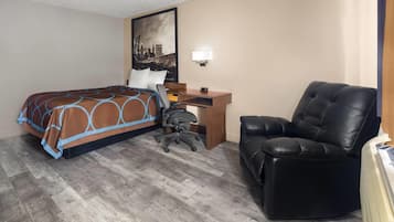 Ein Hotelzimmer mit Bett, Schreibtisch, Stuhl und Stadtbild an der Wand.