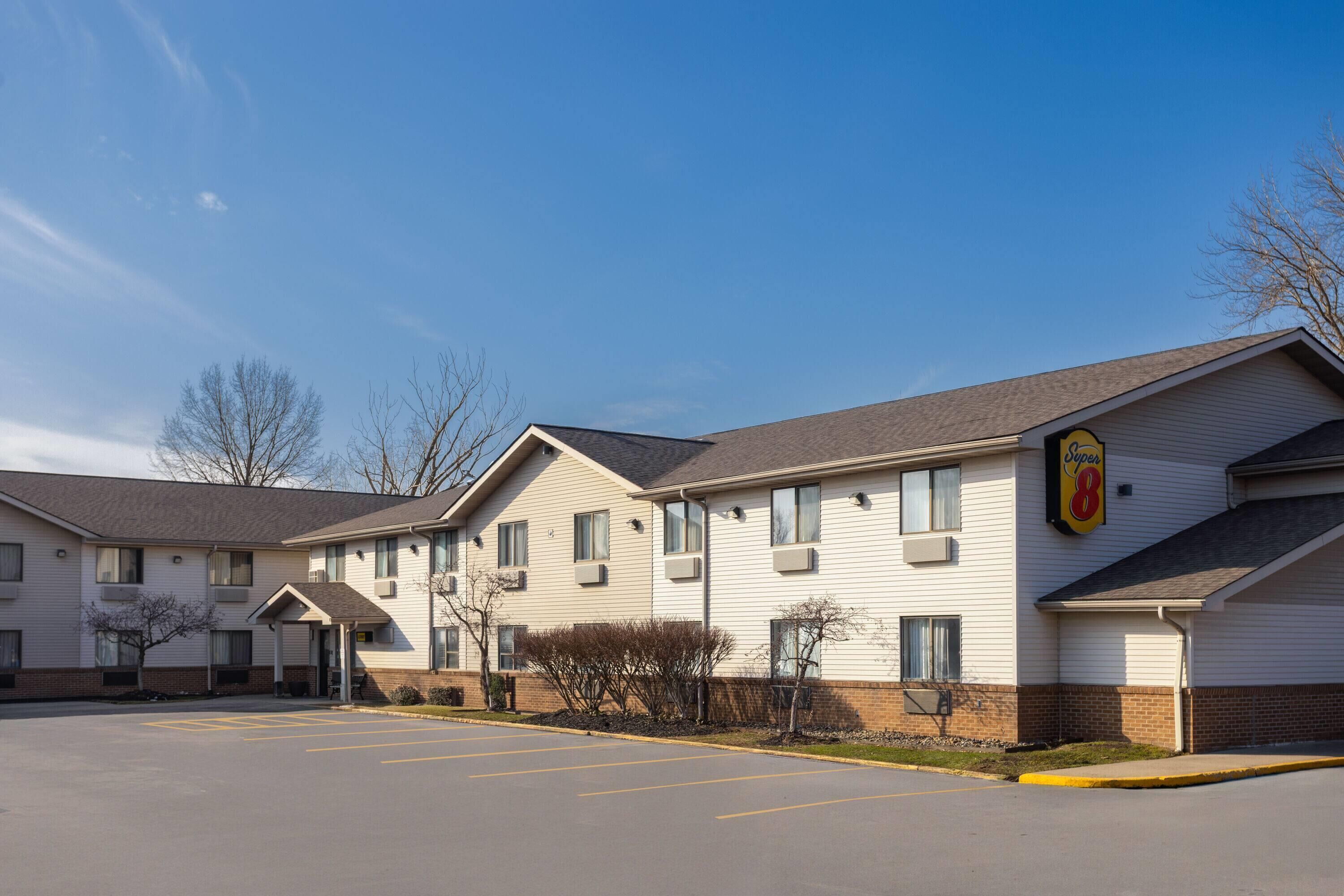 A multi-story motel with a parking lot, a covered entrance, and a Super 8 sign.
