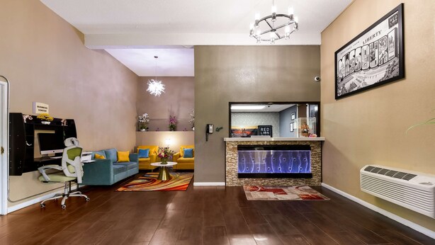 Un salón amplio con chimenea, un centro de negocios y una gran foto enmarcada en la pared.