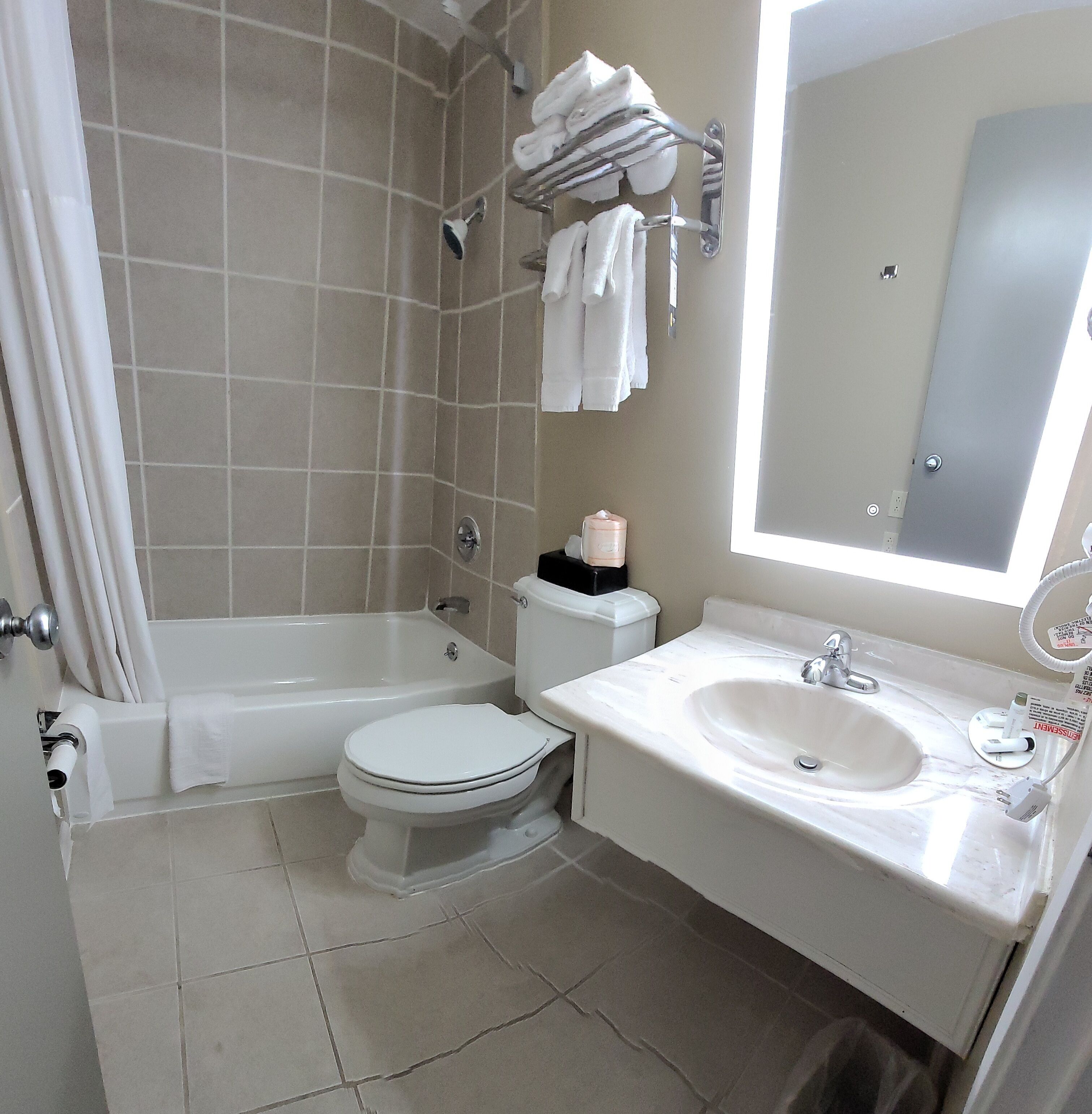 A bathroom with a bathtub, toilet, sink, and a mirror.