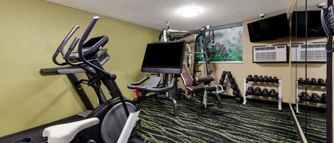 A gym with treadmills, an elliptical, a stationary bike, and a weight bench.
