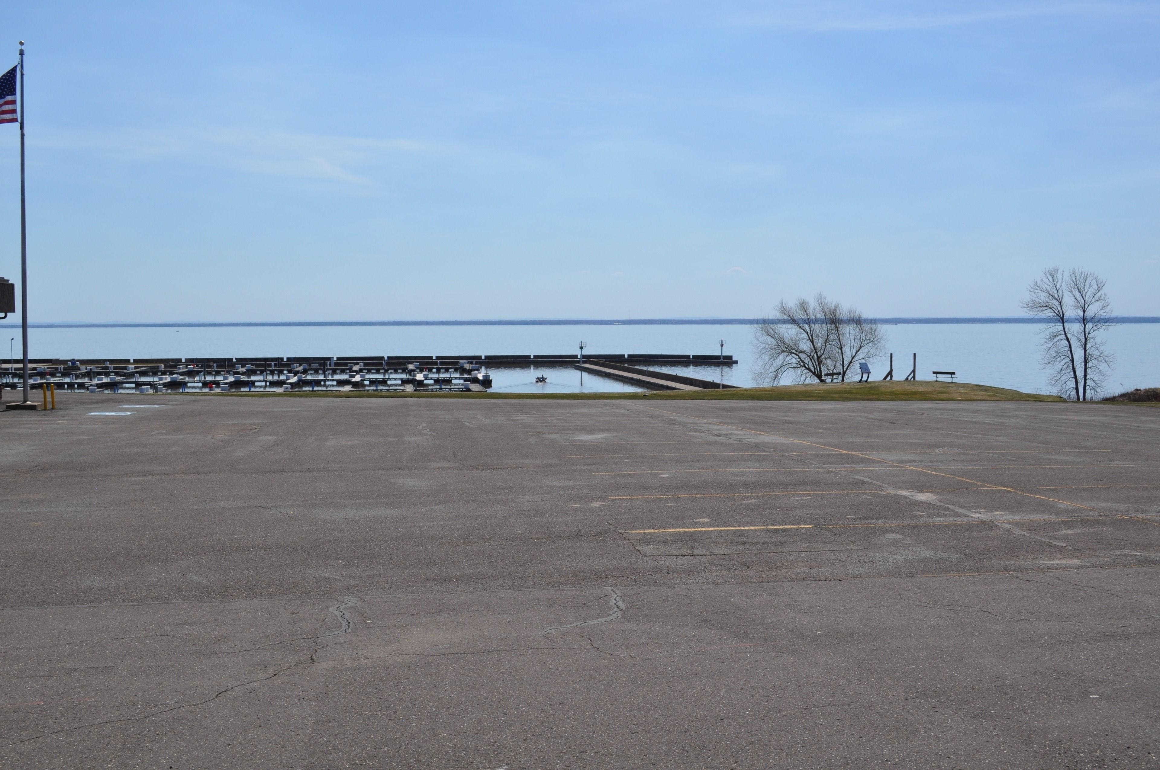 A large parking area with a view of a body of water and a dock.