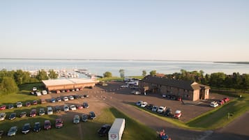 A parking lot with multiple cars and a large building with a brick facade.
