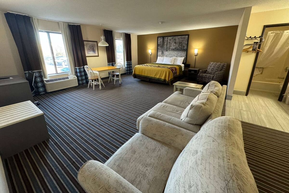 Ein Hotelzimmer mit einem Bett, einem Sofa, einem Schreibtisch und einem Sessel.