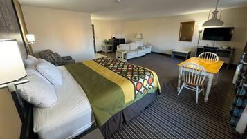 Ein Hotelzimmer mit Bett, Schreibtisch, Stuhl, Fernseher und Lampe.