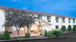Ein Motel mit eingeschossigem Bau, einer überdachten Veranda und einem Parkplatz.