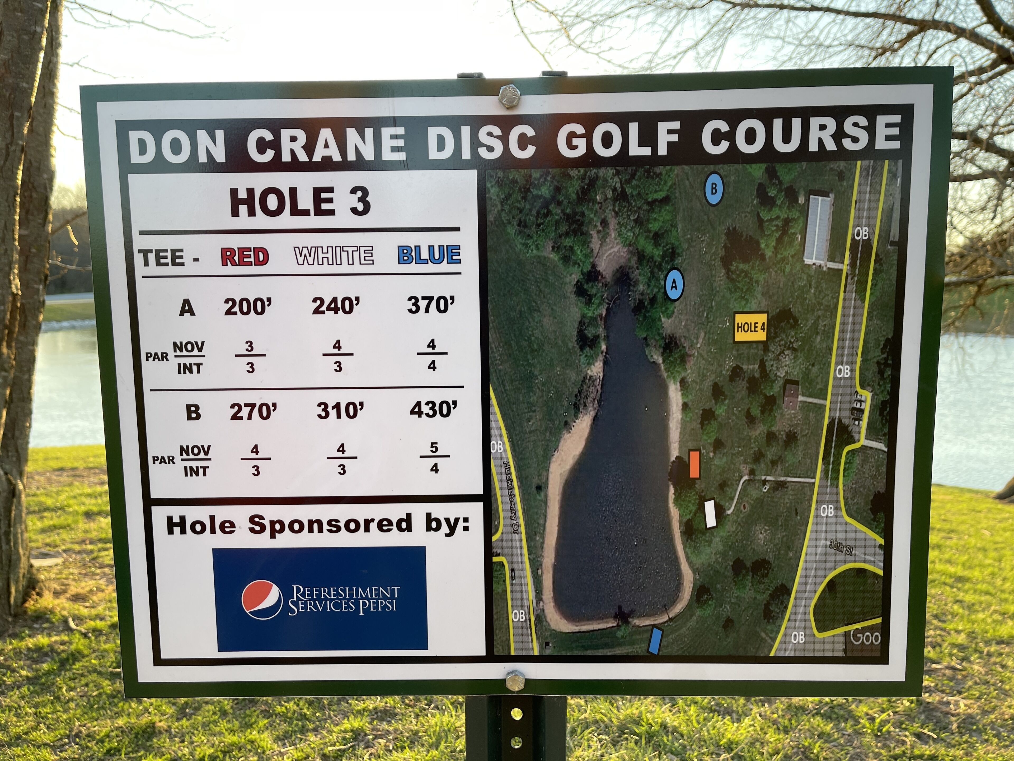 A golf course sign with hole distances and tee box information.