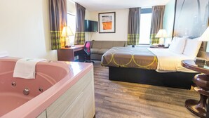 A hotel room with a large bed, a separate desk, a chair, a desk lamp, a TV, and a large window with curtains. - Super 8 by Wyndham Branson/Andy Williams Theater (Branson)