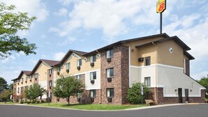 Un hôtel à la façade en briques, doté de nombreuses fenêtres et d’une enseigne indiquant un commerce situé à proximité.