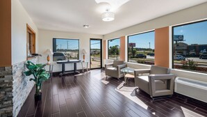 A spacious room with a large window, a ceiling light fixture, and a potted plant. - Americas Best Value Inn & Suites Harrisonville (Harrisonville)