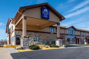 Un hotel con fachada de piedra, un acceso cubierto y un cartel que indica que forma parte de la cadena Americas Best Value Inn & Suites.