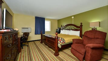Ein Hotelzimmer mit Bett, Stuhl, Kommode und Fernseher.