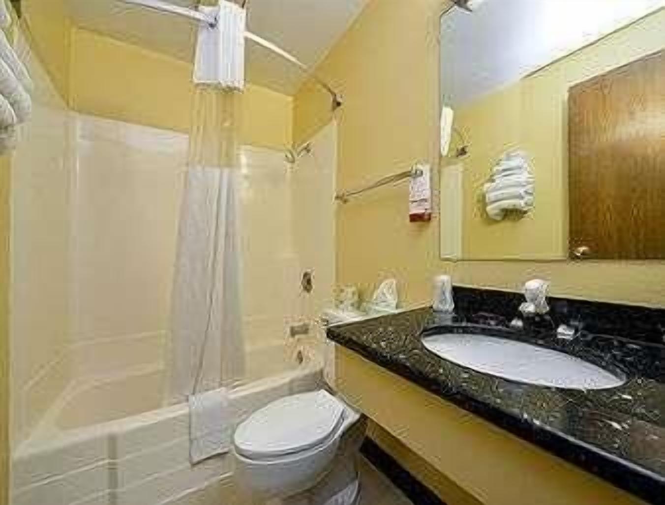 Un baño con bañera, inodoro y lavabo.