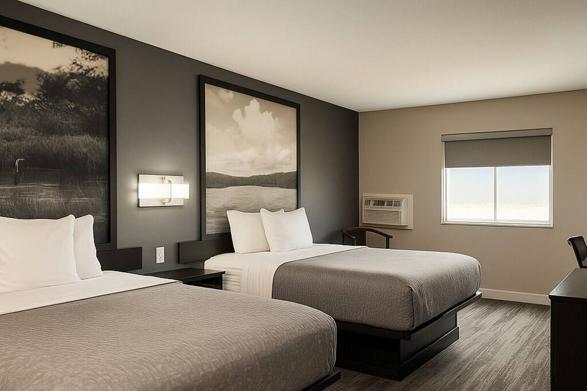 A hotel room with two beds, a large window, and artwork on the walls.