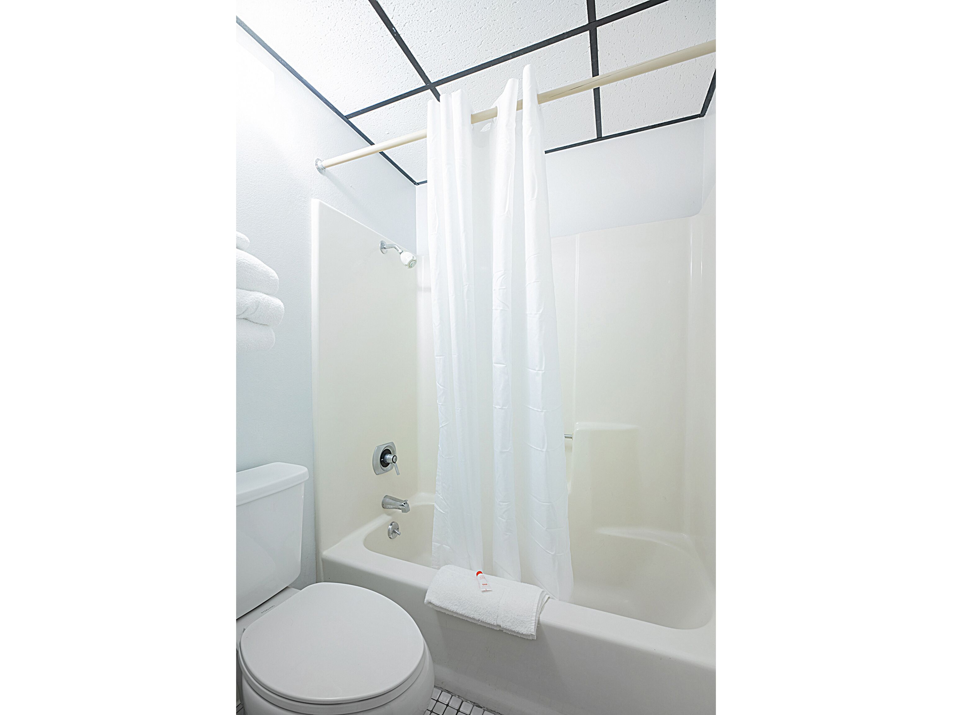 Een badkamer met een bad, toilet en een douchegordijn.
