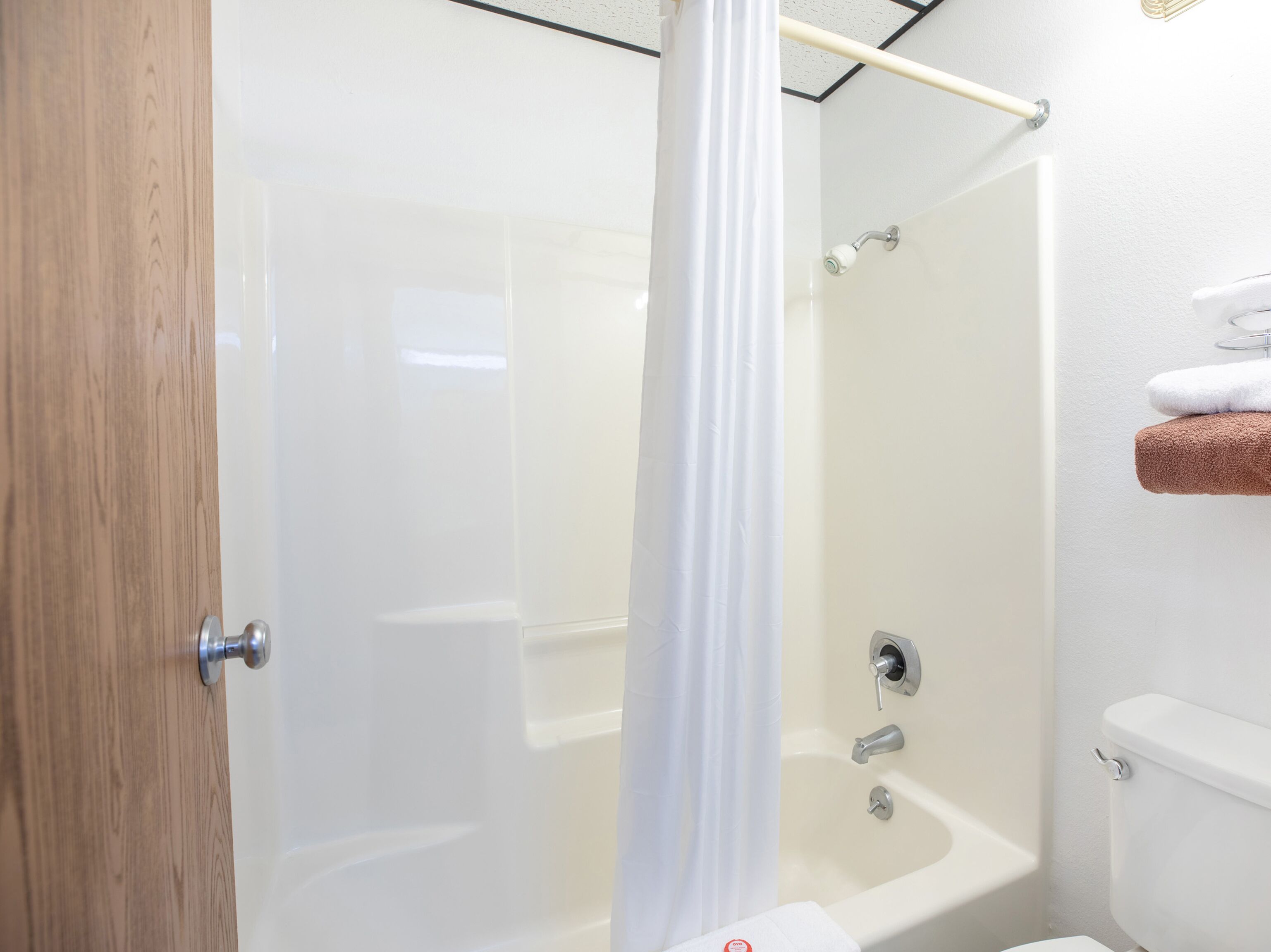Une salle de bain équipée d’une douche, de toilettes et d’un porte-serviettes avec des serviettes.