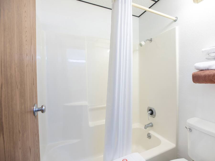 Une salle de bain équipée d’une douche, de toilettes et d’un porte-serviettes avec des serviettes.