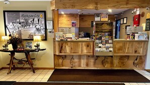 A reception area with a wooden counter, a framed welcome sign, and various informational posters.