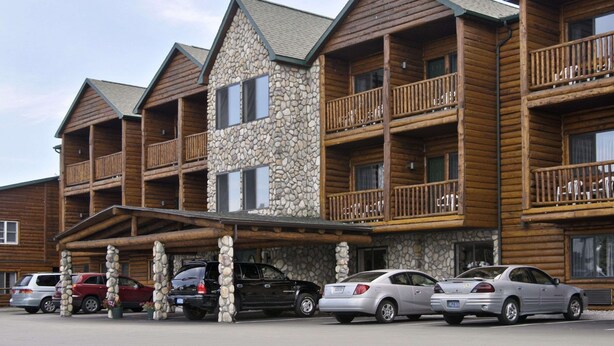 A multi-story lodge with stone and wood exterior, balconies, and a covered parking area.
