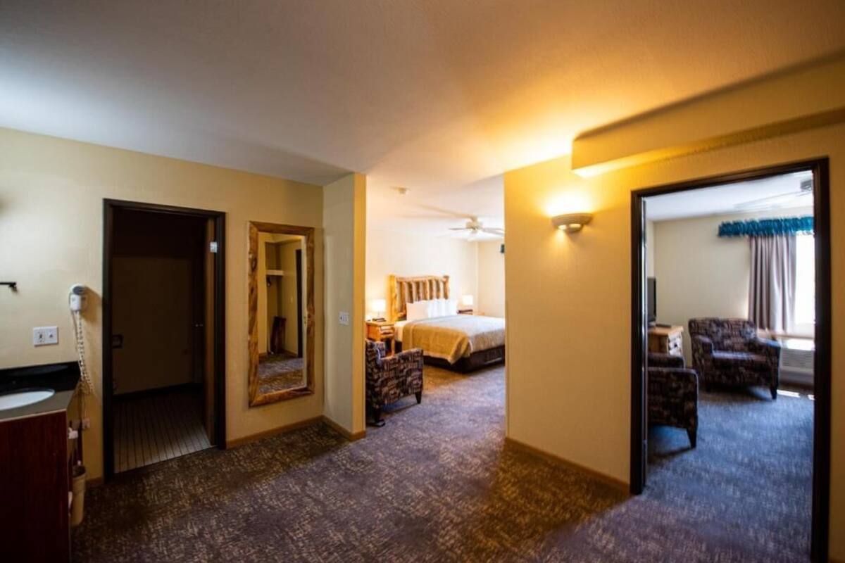 Une chambre d’hôtel avec un lit, un bureau, une chaise et une salle de bain.