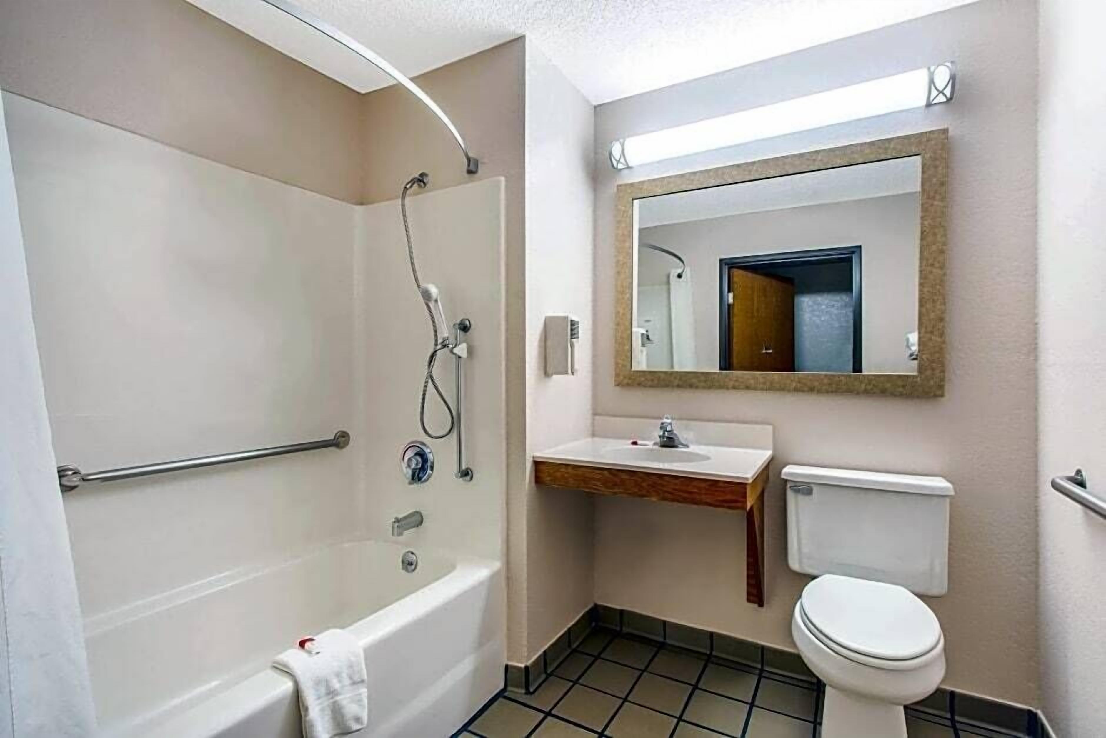 Une salle de bain avec une baignoire, des toilettes, un lavabo et un miroir.