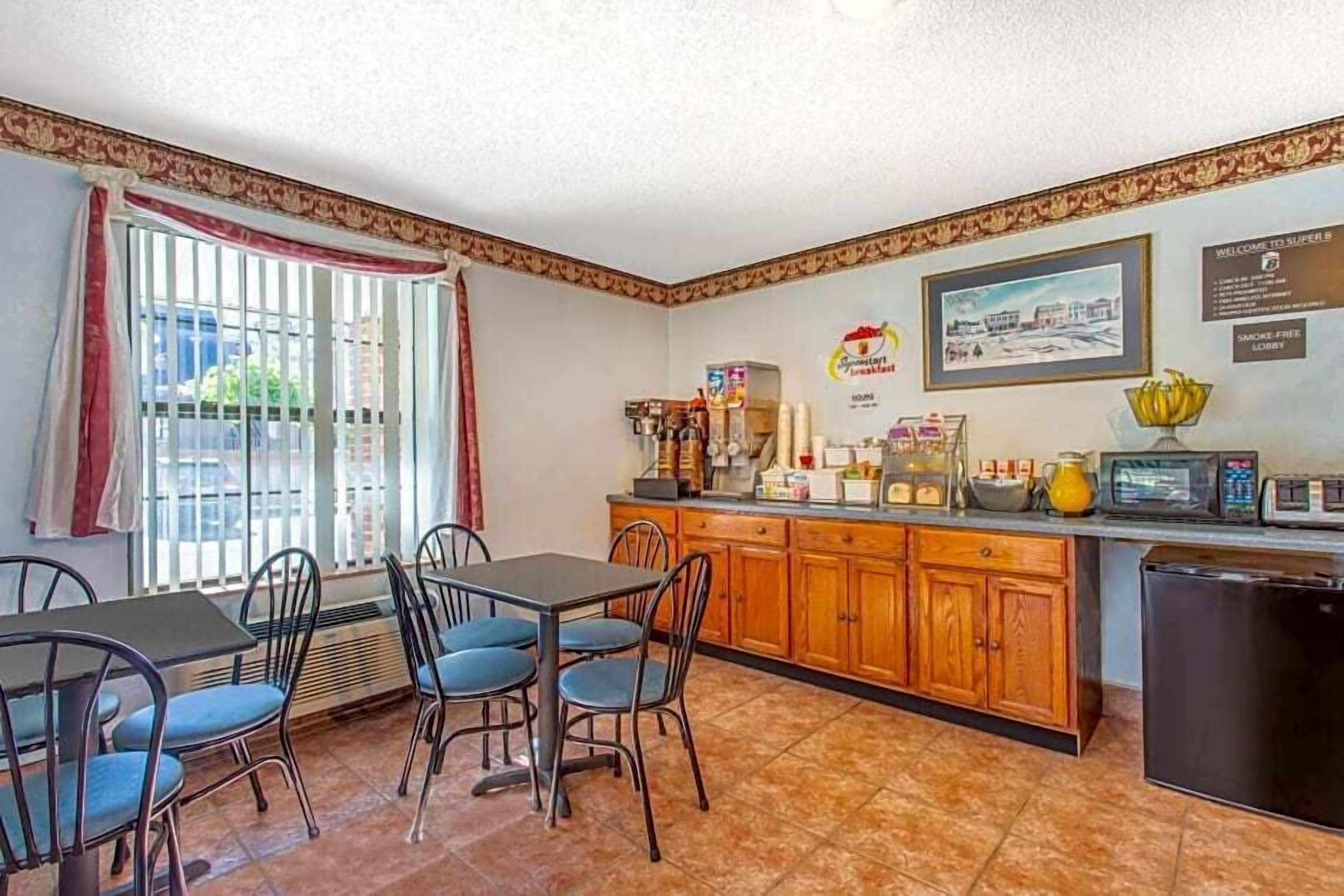 A compact kitchen with a dining area, featuring a refrigerator, microwave, and various kitchen appliances.