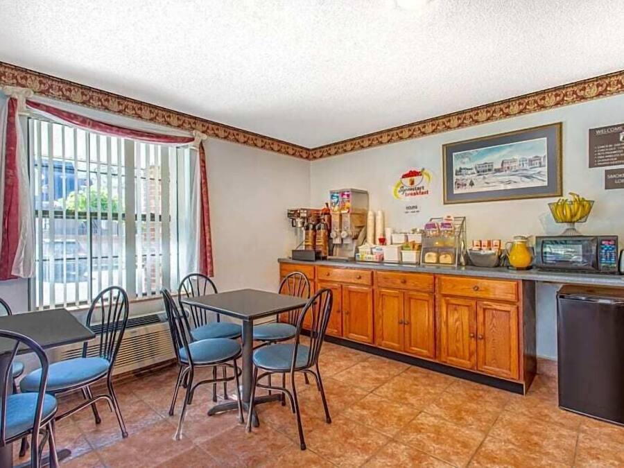 A compact kitchen with a dining area, featuring a refrigerator, microwave, and various kitchen appliances.