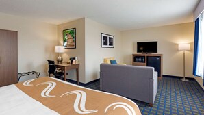 A hotel room with a bed, a desk, a television, a microwave, and a sofa. - Quality Inn Lee - Lenox South (Lee)
