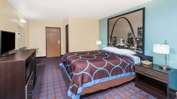 A hotel room with a bed, a desk, a television, and a cityscape mirror.