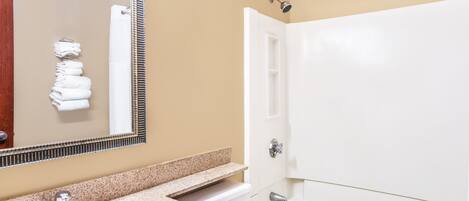 Un baño con lavabo, espejo, toallero y bañera.