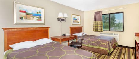 Habitación de hotel con dos camas, un escritorio, una silla, una lámpara y una ventana con cortinas.