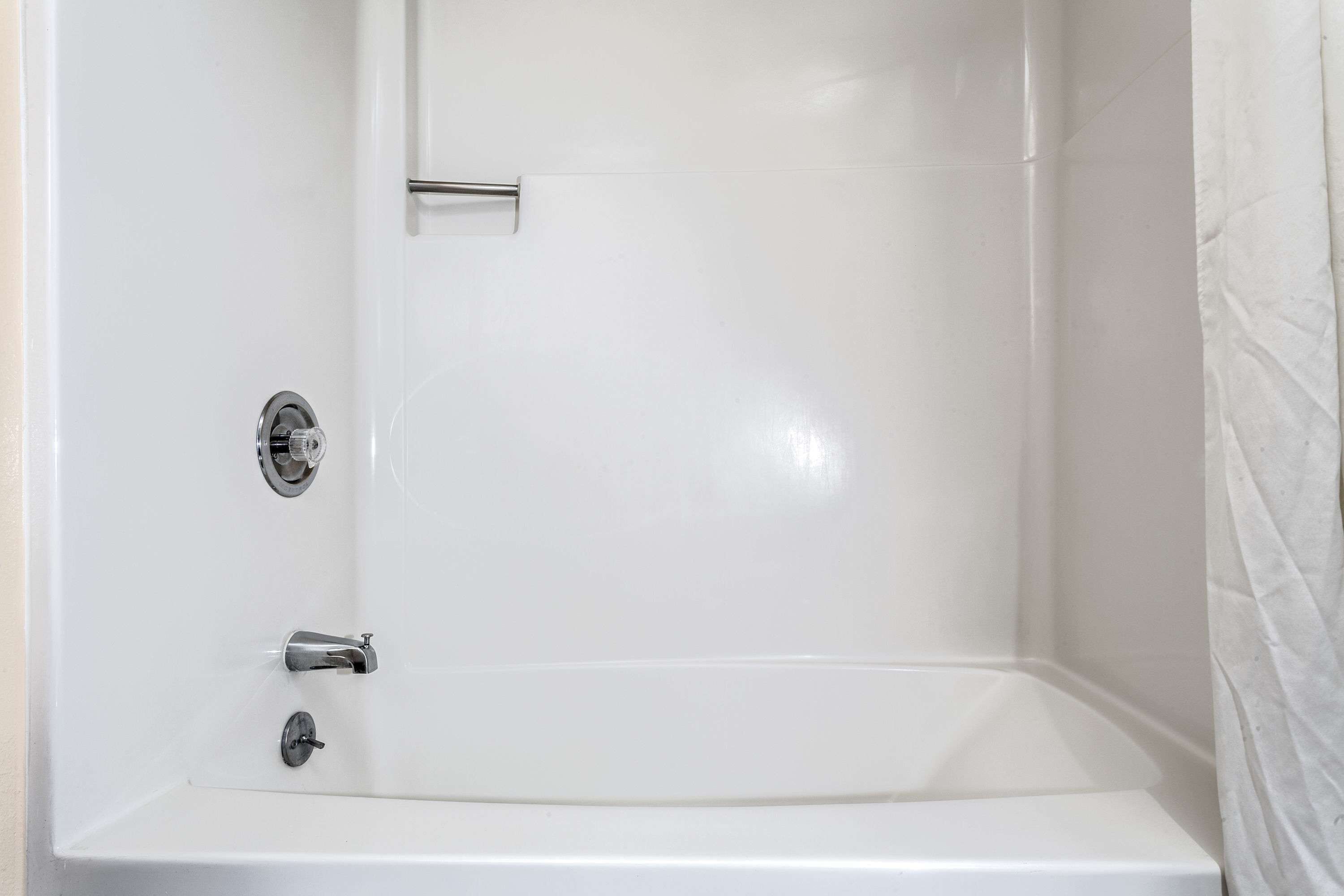 Una bañera blanca con grifería de cromo en un baño.