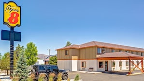 A motel with a large 'Super 8' sign, a parking lot, and a building with a red roof. - Super 8 by Wyndham Carson City/Lake Tahoe (Carson City)