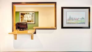 A room with a desk and a framed landscape painting on the wall. - Super 8 by Wyndham Carson City/Lake Tahoe (Carson City)