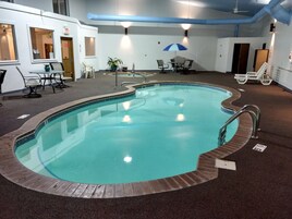 Una piscina techada, sillones reclinables de piscina