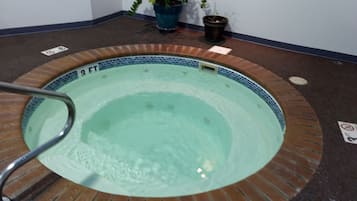 Relax in a hot tub surrounded by lush greenery.