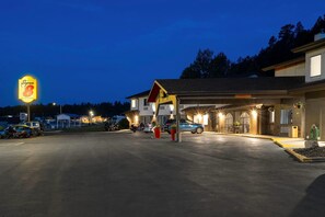 A gas station with a prominent 'Super 8' sign, a parking area with several vehicles, and a building with a 'Clearance 8' sign. - Super 8 by Wyndham Custer/Crazy Horse Area (Custer)