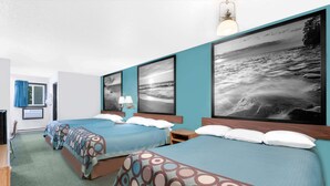 Habitación de hotel con dos camas, un escritorio y una silla.