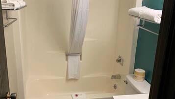 A bathroom with a bathtub, toilet, and a shower curtain.