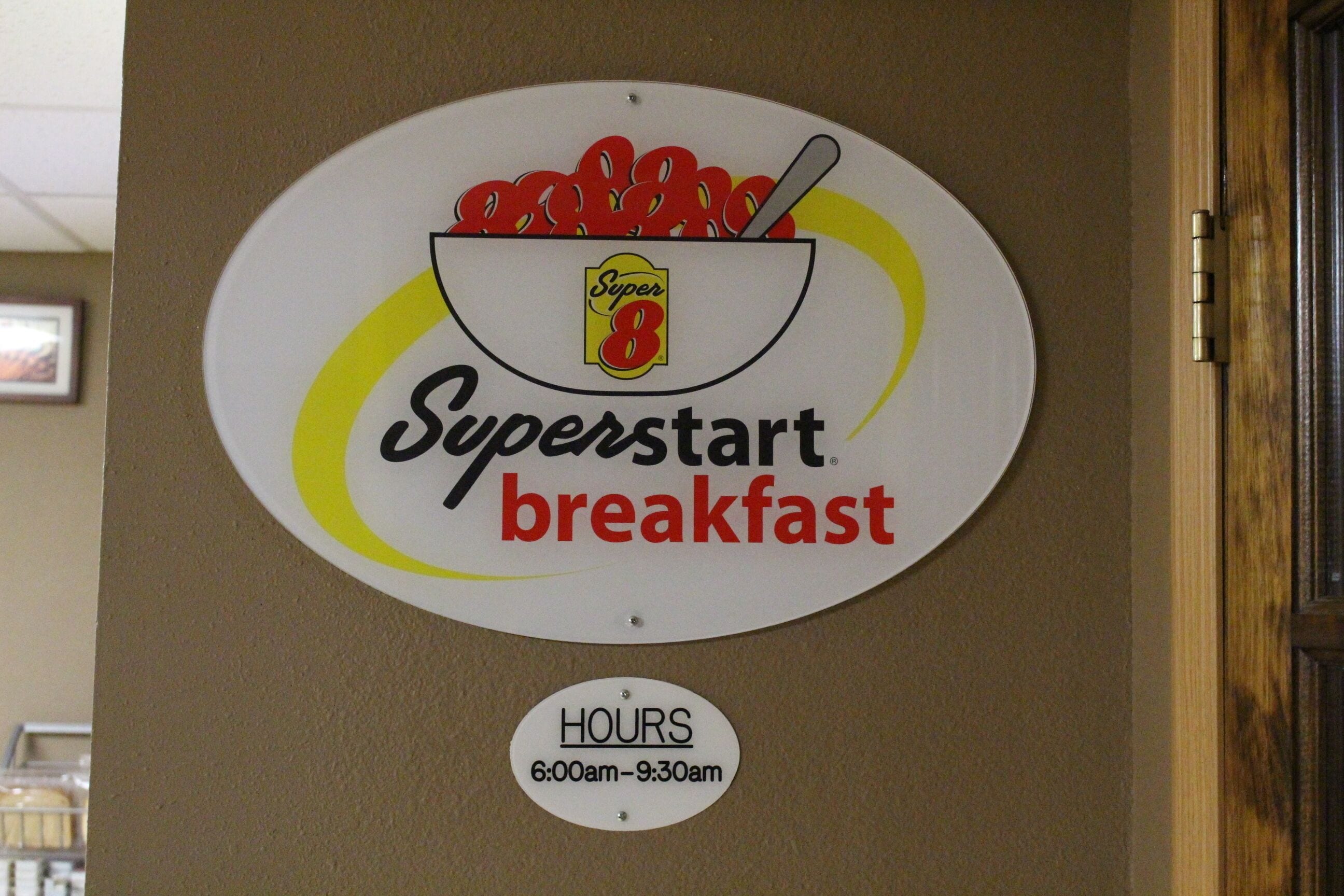 A wall sign for Superstart breakfast with operating hours from 6:00am to 9:30am.