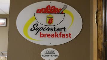 A wall sign for Superstart breakfast with operating hours from 6:00am to 9:30am.