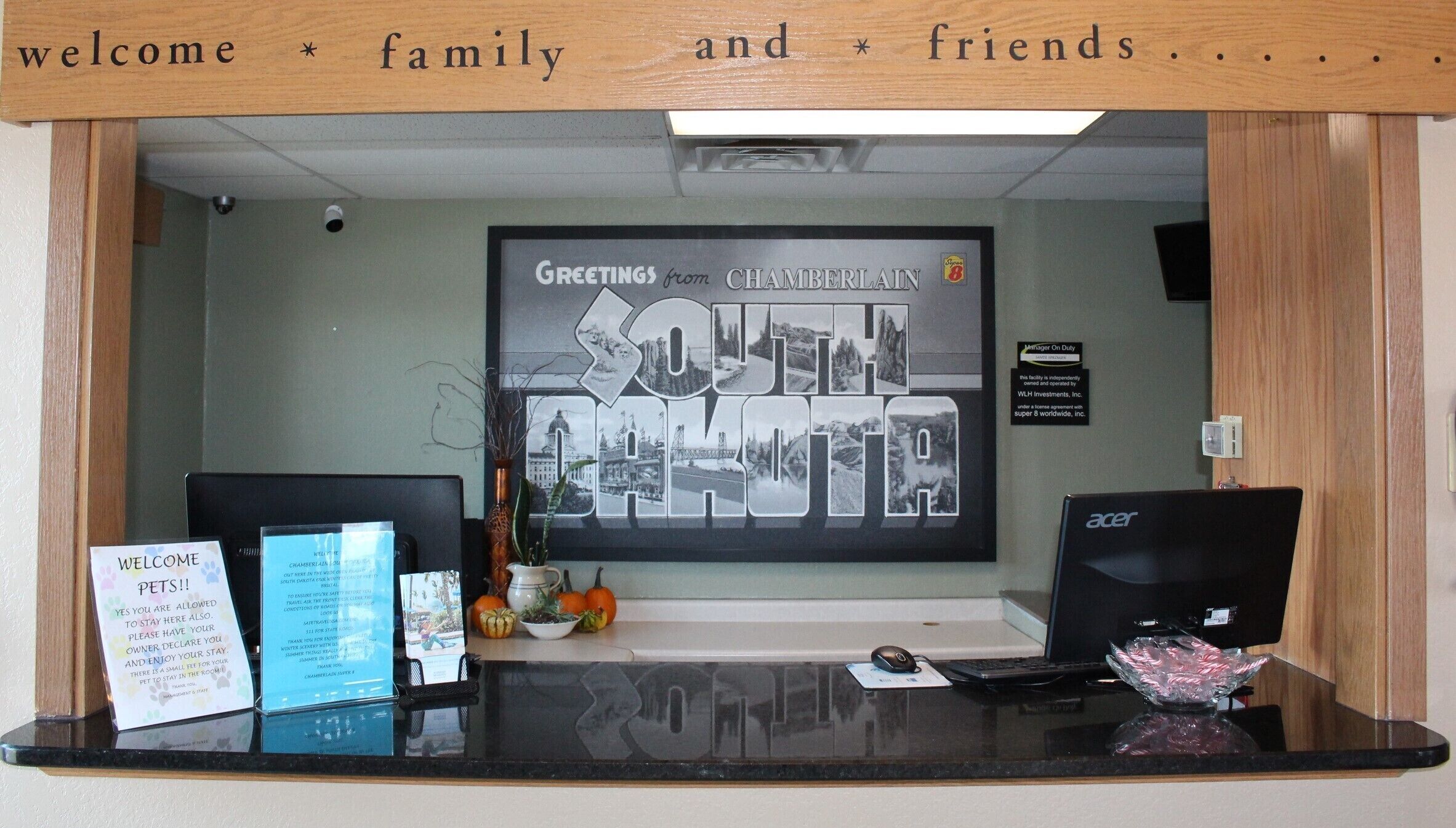 A reception desk with a welcome sign for family and friends, a framed photo of Chamberlain, South Dakota, and a sign indicating the facility is independently owned.