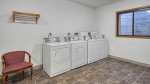 Une buanderie équipée d’une chaise en bois, d’un lave-linge et d’un sèche-linge.