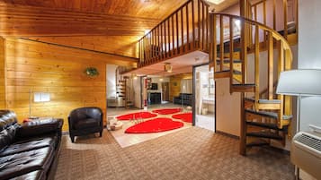 Suite, 1 cama de matrimonio grande, bañera de hidromasaje | Zona de estar | Televisión de 32 pulgadas con canales por cable