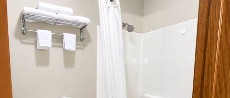 Un baño con inodoro, ducha y perchero.