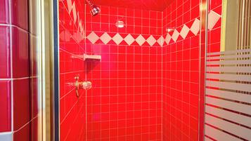Experience a sleek bathroom with a curved shower area and geometric tile pattern.