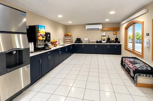 Cocina moderna con electrodomésticos de acero inoxidable, dispensador de jugo y vista al estacionamiento.