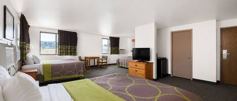 A hotel room with two beds, a desk, a television, and a wardrobe.