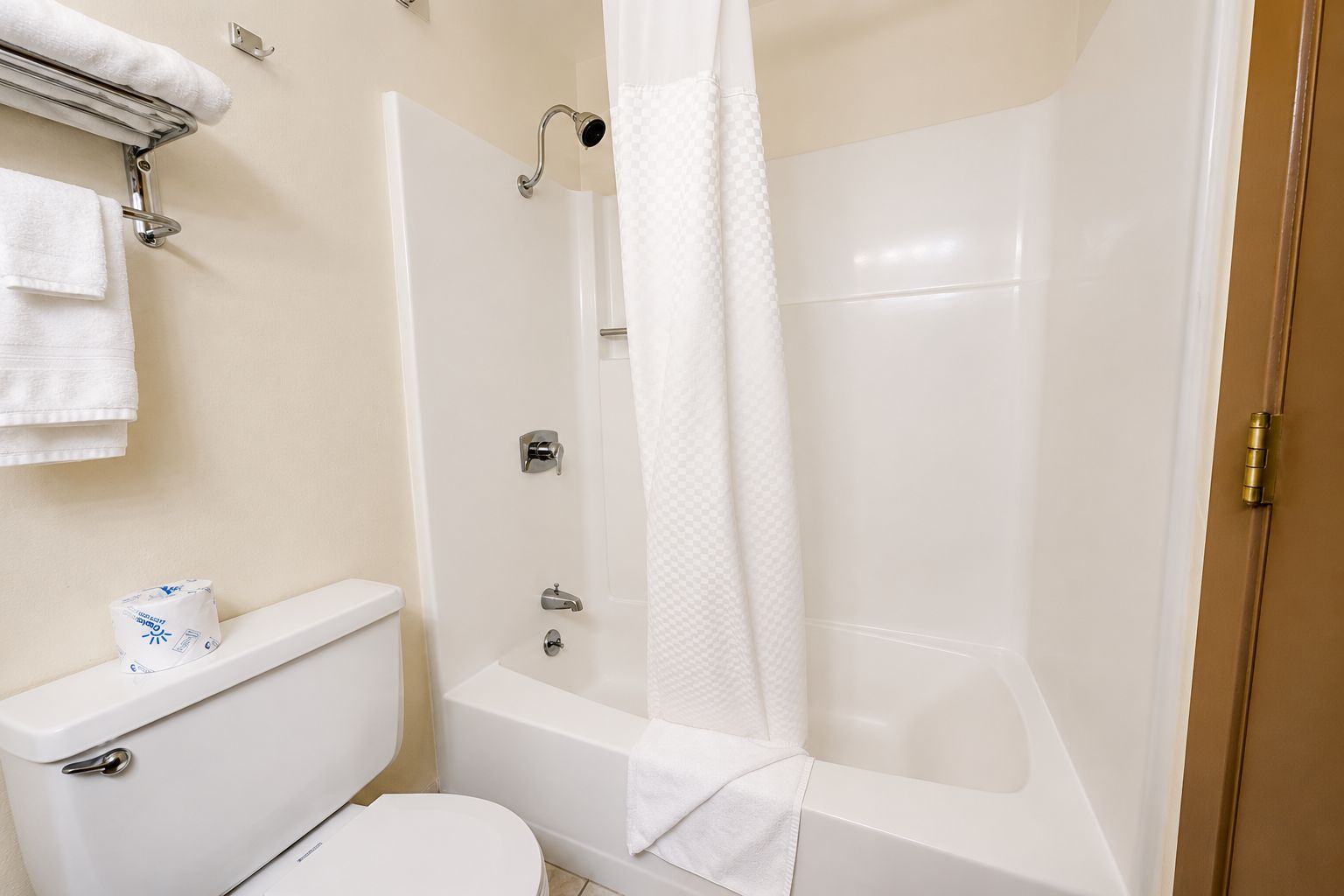 Une salle de bain avec des toilettes, une baignoire et un rideau de douche.